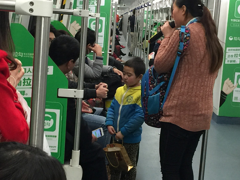 在女人带领下乞讨的孩子